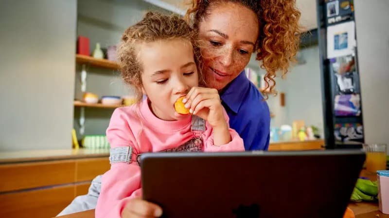Ouder en kind kijken samen op een tablet